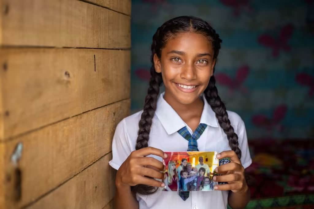 Ein Mädchen in Kolumbien zeigt ein Foto ihrer Patin.