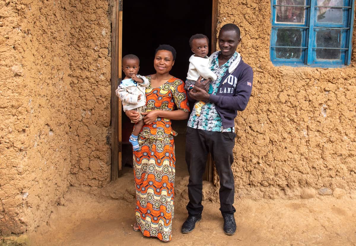 Una famiglia beneficiaria del programma di Compassion in Ruanda con in braccio i propri figli,