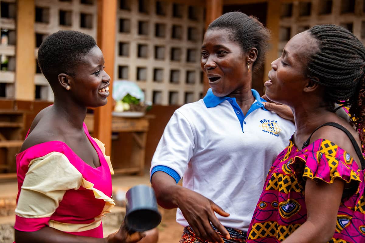 Denise mit einer Behinderung an der Hand und drei weitere Teilnehmerinnen des Überlebensprogramms von Compassion in Togo.